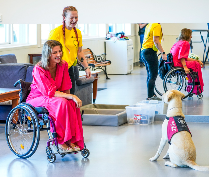 Prinsesse Märtha Louise får prøve seg i rullestol, med assistanse av den kommende servicehunden Zeke. Foto: Lise Åserud / NTB